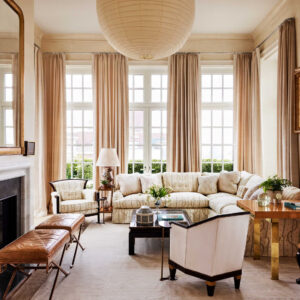 Modern living room interior design with beige sofa, wooden center table, wall decor, large window, and minimalist decor style.